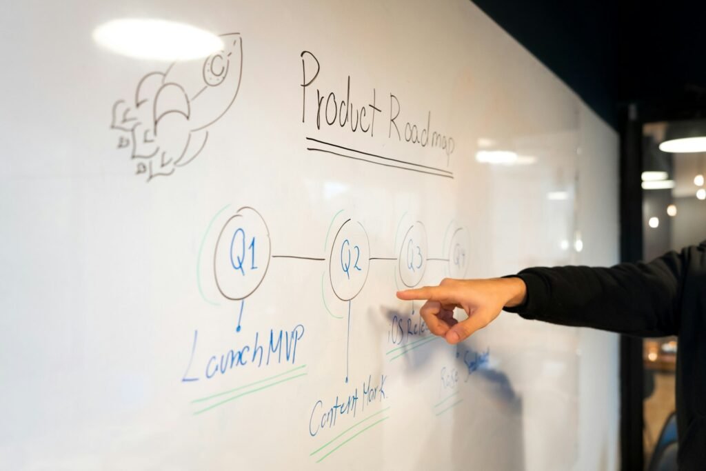 Best AI Tools for Product Managers (2026): Tested by Job Product manager mapping a plan on a whiteboard, representing AI tools for product discovery, specs and delivery