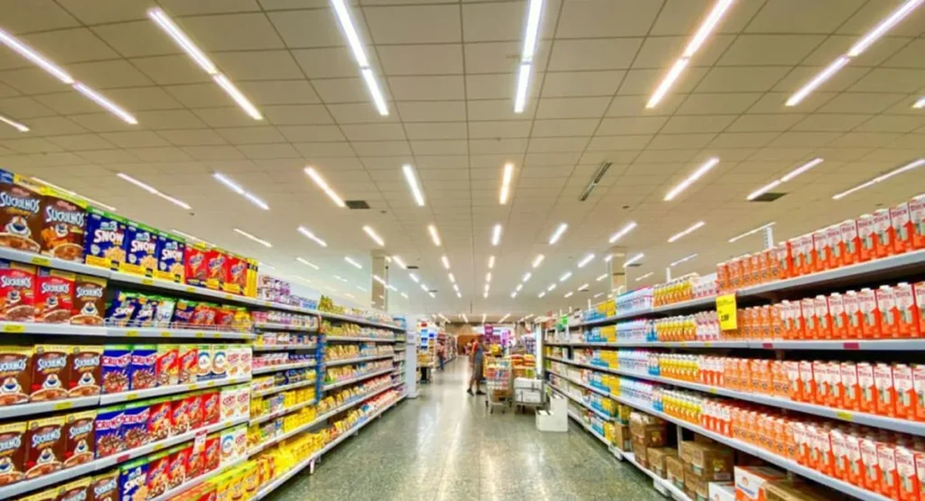 Long supermarket aisle stocked with consumer goods, the products shoppers now research in AI answers