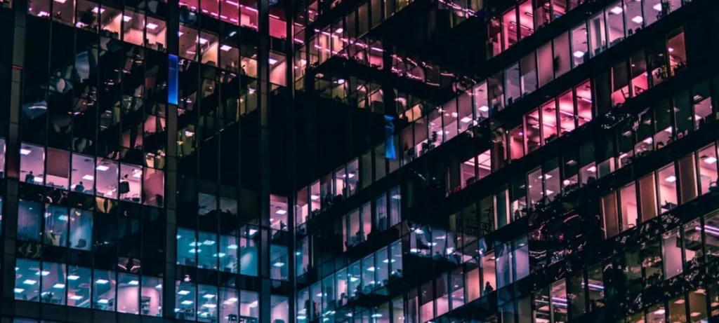 Best AI Visibility Tools for Enterprise 2026 Office tower at night with lit windows, representing enterprises choosing AI visibility tools