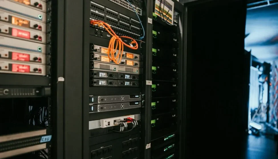 Server rack with orange network cables, the infrastructure AI ops monitoring tools watch for performance issues