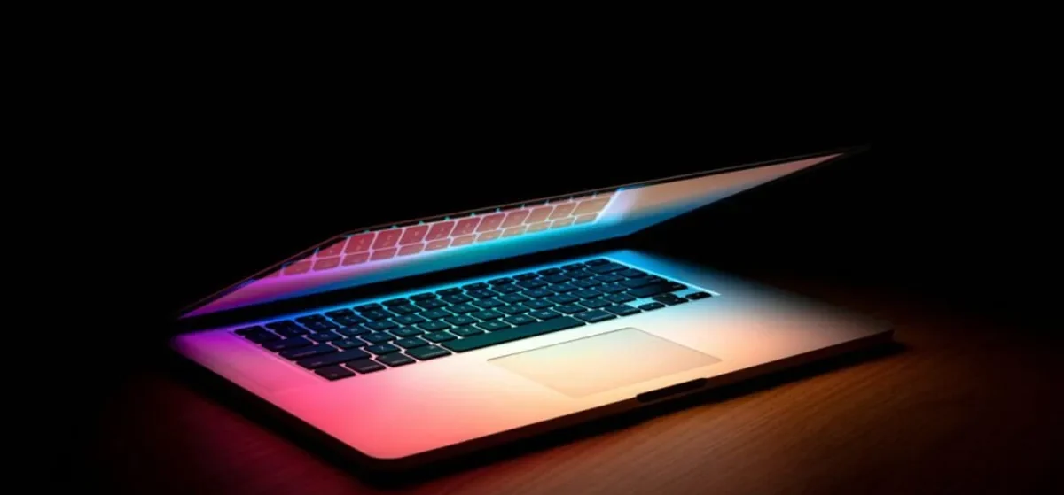 Working through AI tools SEO marketing 2025 Laptop with a glowing multicoloured keyboard in a dark room, the workspace of an SEO marketer using AI tools