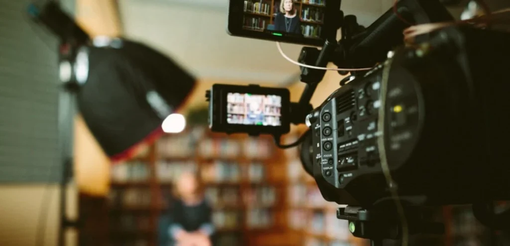 Video camera and monitor on an interview set, where AI voice generators now handle narration and dubbing
