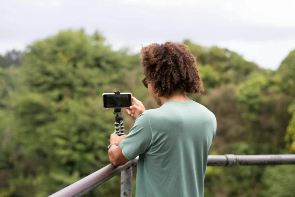 Creator filming short-form video on a phone tripod, a use case where AI voiceover pricing per minute matters