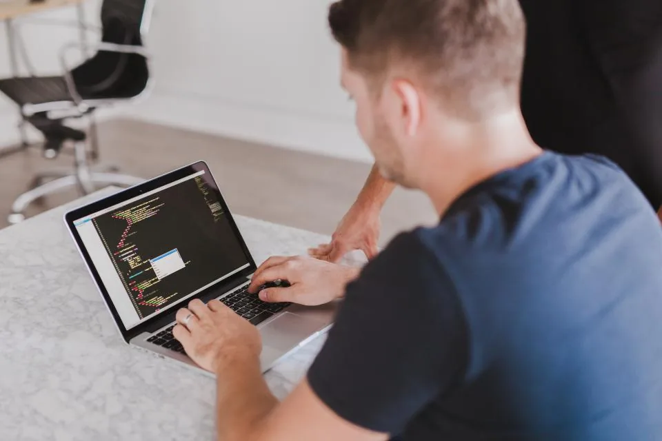 Developer typing on a laptop while a local language model runs in the background