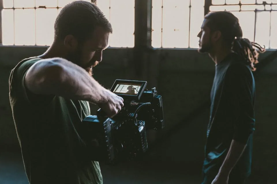 Two filmmakers checking a camera monitor, the kind of small crew that benefits from local video generation