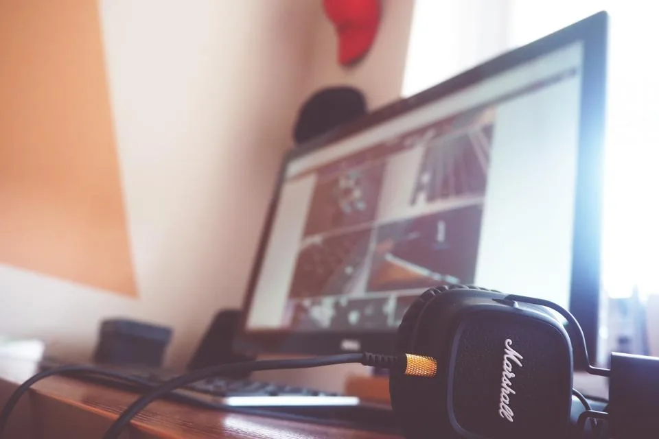 Home desktop computer with headphones Desktop computer on a home desk with headphones, the kind of personal machine that can run local AI